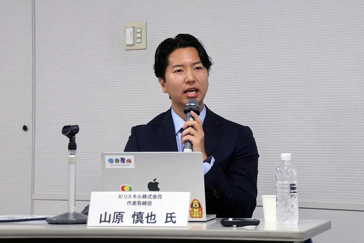 マイクを持って話す講師の山原慎也